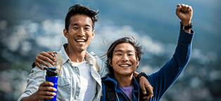 a male couple with arms around each others sholder greeting picture taker with a smile and cheers